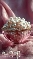 Sparkling pearls displayed elegantly in a delicate glass bowl against a soft pink backdrop photo