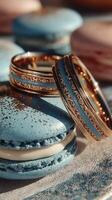 Exquisite gold rings resting on delicate blue macarons at a dessert table photo