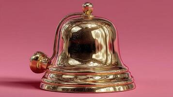 Shiny golden bell with polished surface on a pink background highlighting craftsmanship and design details photo