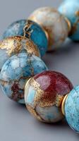 Colorful gemstone beads with intricate designs displayed against a neutral backdrop in a close-up view photo