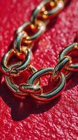 Close-up view of a gold chain linked on a vibrant red background showcasing its intricate design and shine photo