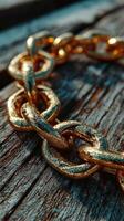 Close-up view of a golden chain resting on a weathered wooden surface revealing intricate details and textures during daylight photo