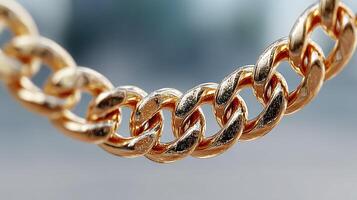 Close-up view of a shiny gold chain featuring intricate links on display in a bright outdoor setting during daylight photo