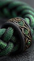Intricate green braided rope with decorative metal accent under soft lighting photo