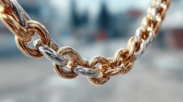 Shining gold and silver chain sparkling in sunlight outdoors against a blurred city background photo