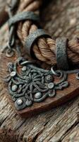 Intricate metalwork detailed with braided rope on rustic wooden surface conveys a sense of craftsmanship and history photo