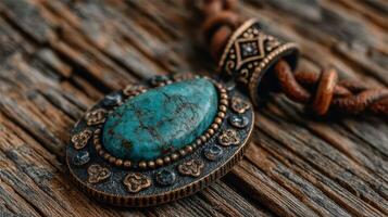 Turquoise pendant resting on rustic wooden surface highlighting intricate metalwork details photo