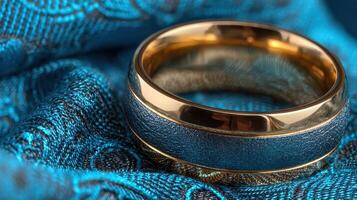 Elegant wedding ring rests on luxurious blue fabric, showcasing intricate design and craftsmanship in a close-up shot photo