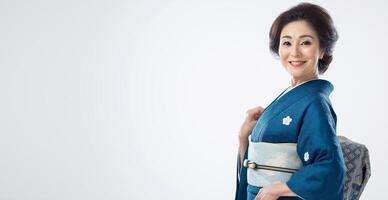 A woman wearing a blue kimono is smiling and posing for the camera photo