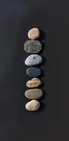 A row of rocks with one of them being black photo