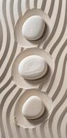 Three white rocks are placed in a sand-like setting photo