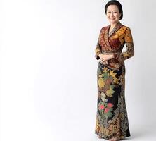 A woman wearing a colourful dress is smiling for the camera photo