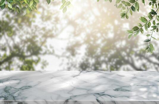 A marble table with a view of trees and leaves. The table is empty and has a lot of natural light coming through the trees photo