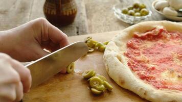 Making homemade pizza. Hands cutting olives for pizza video
