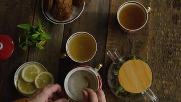 Drinking tea. Woman adding sugar to cup of brewed green tea. Top view video