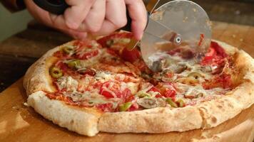 Pizza cutter cuts homemade baked dough. Making pizza with mushrooms and olives video