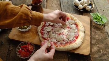 Making homemade pizza with mushrooms. Female hands putting ingredients on pizza video