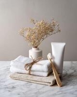 A white towel, toothbrush and toothpaste are on a marble counter photo