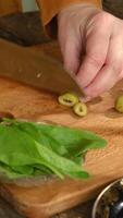 Vertical . Cooking process. Female hands cutting olives on chopping board. video