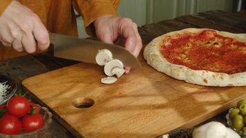 Making pizza. Hands cutting champignons mushrooms for pizza. video