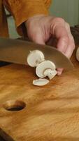 Vertical . Slicing mushrooms champignons on cutting board video