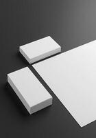 Blank white paper and business card mockup on black background photo