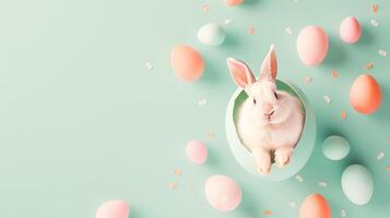 Easter bunny in egg on turquoise background with easter eggs and confetti photo
