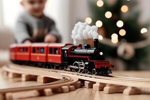A small child playing with a toy train on a wooden table photo