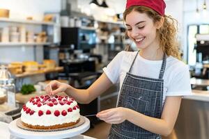 A woman in an apron is holding a cake photo