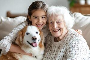 A young girl and an older woman sitting on a couch with a dog photo