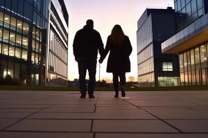 A couple walking in front of a building at sunset photo