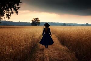 A woman in a blue dress walks through a field photo