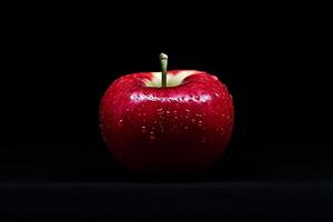 A red apple is shown on a black background photo