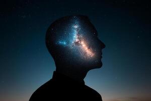 The silhouette of a man's head with the milky way in the background photo