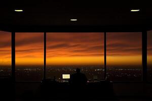 A person sitting at a desk in front of a window photo