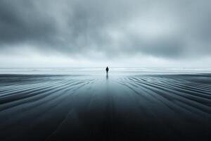 A lone person standing on the beach in the middle of the ocean photo