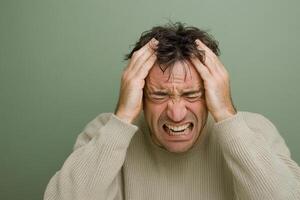 A man is holding his head with both hands photo