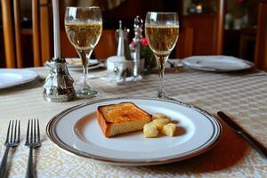 A plate with a piece of bread and a glass of champagne photo