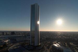 The sun is shining brightly on a tall building photo
