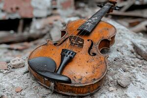 An old violin laying on the ground in front of a building photo