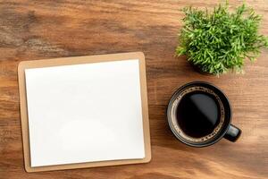 Blank paper and cup of coffee on wooden table top view photo