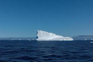A large iceberg floating in the ocean photo