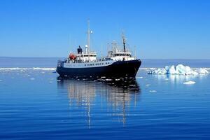 A large boat floating in the ocean near icebergs photo