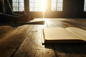 A person sitting at a table with an open book and pen photo