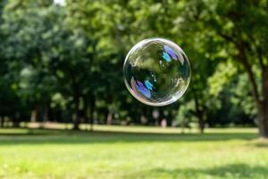 A soap bubble floating in the air over a grassy field photo