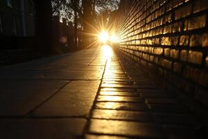 A brick wall with a sun setting behind it photo