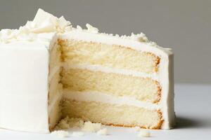 A slice of white cake with frosting on top photo