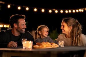 A family sitting at a table with candles and a candle photo