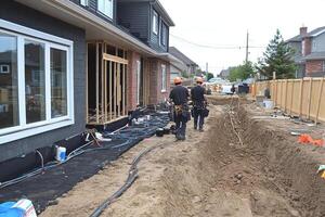 A group of men working on a house in the dirt photo