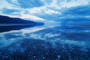 A lake with rocks and water reflecting the sky photo
